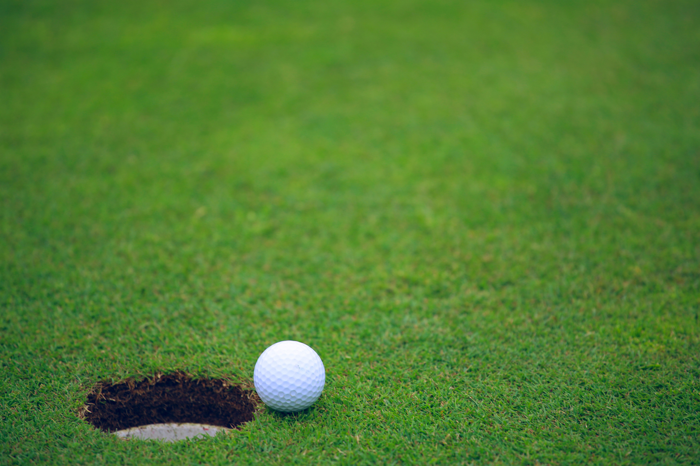 Golf ball on lip of cup